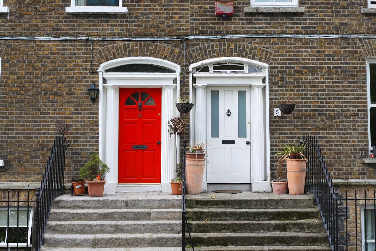 Georgian terrace front doors, one red, one white, up stone steps